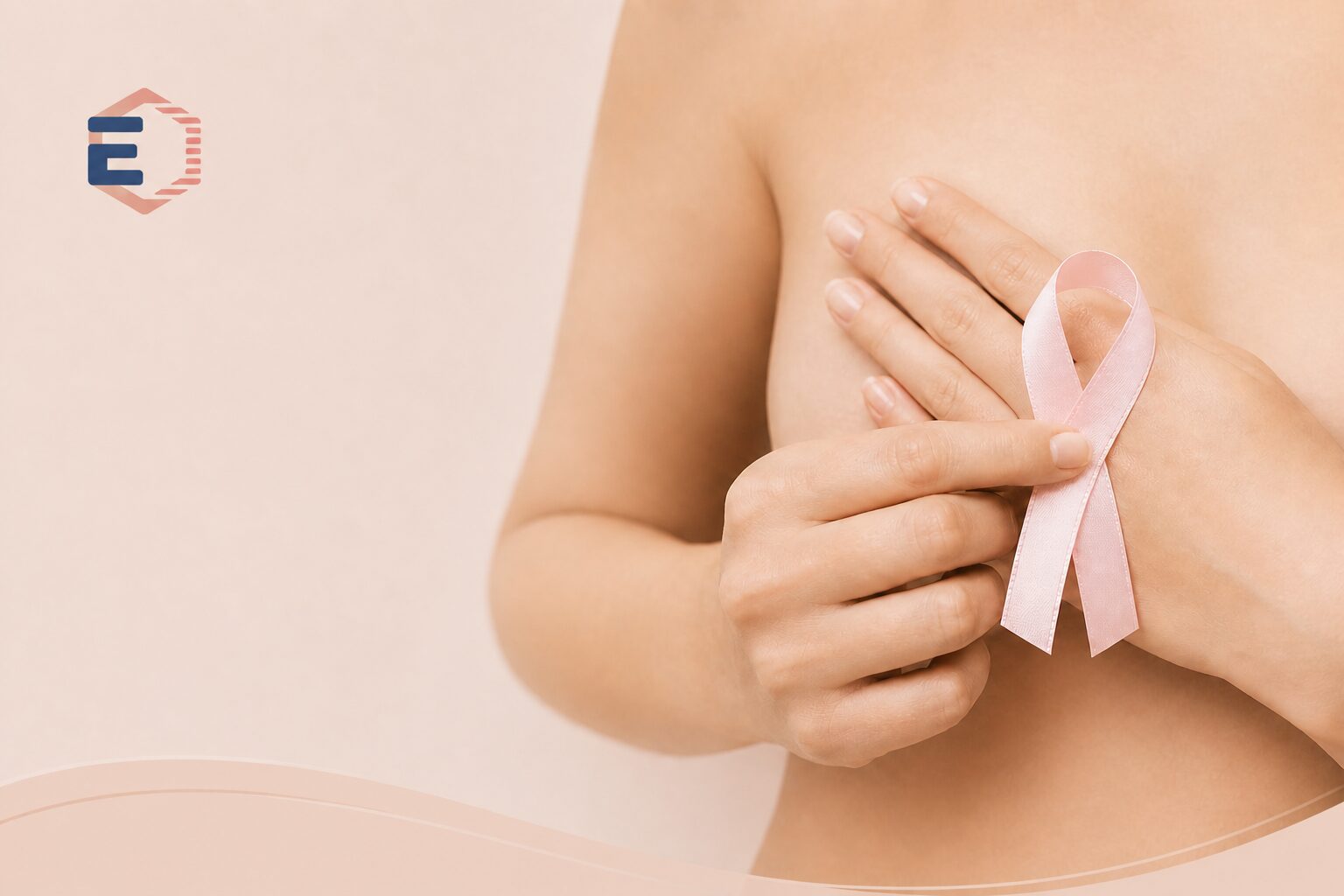 Ruban rose tenu contre la poitrine symbolisant un accompagnement en oncologie et un soutien bienveillant